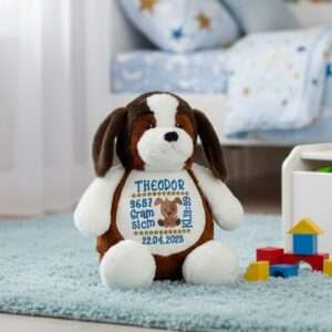 Hund bamse med navn og dato brodert med navn og dato sitter på gulvet i et barnerom.